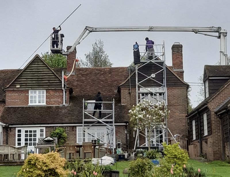 The Moss Cleaners using cherry picker and scaffolding to clean roof safely and professionally in Southwater, West Sussex